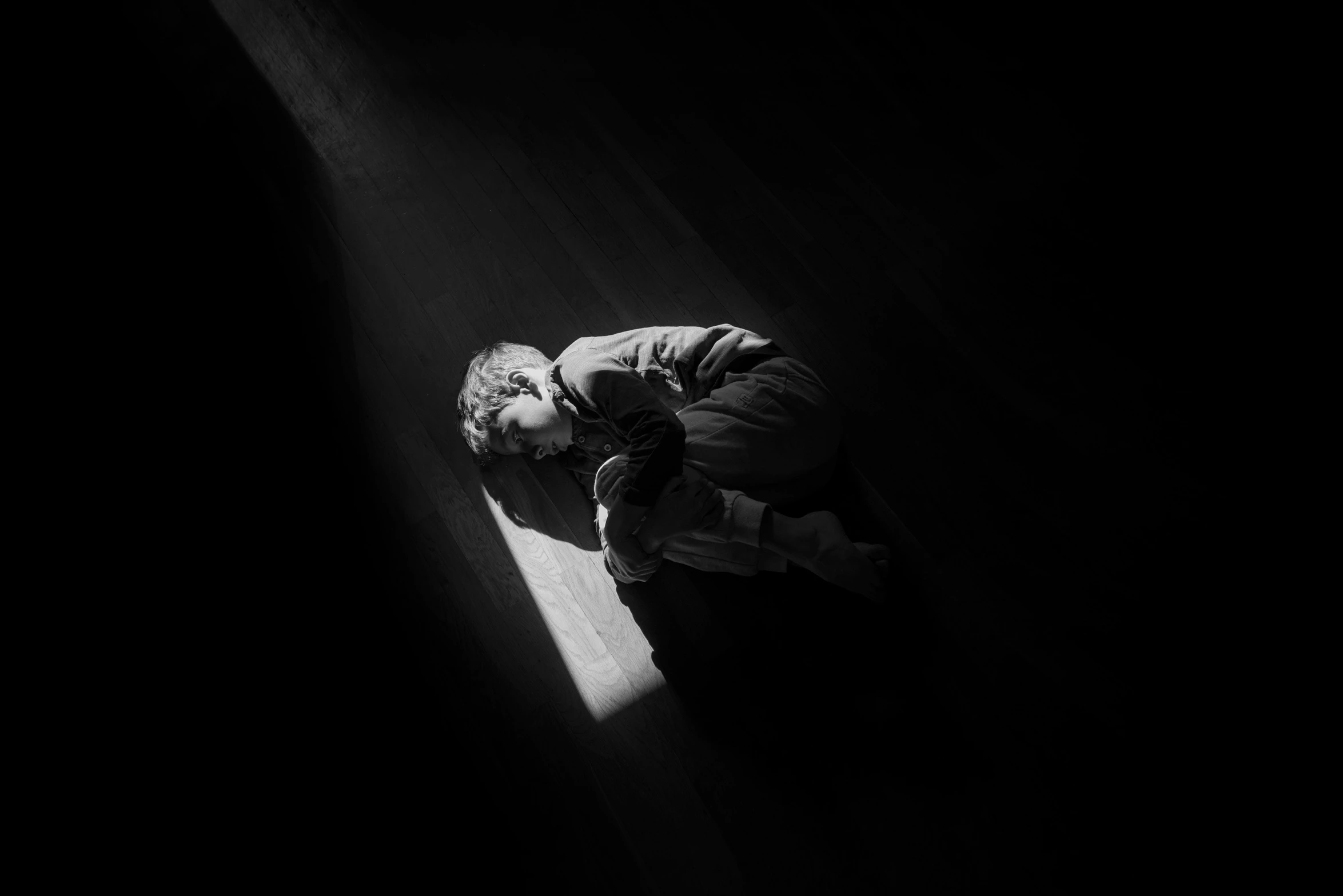 a person who is laying on the floor in the dark