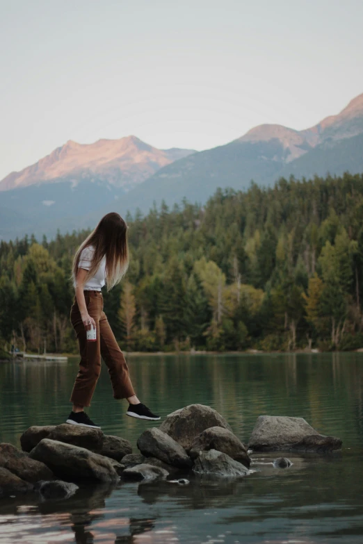 there is a girl that is walking on the rocks