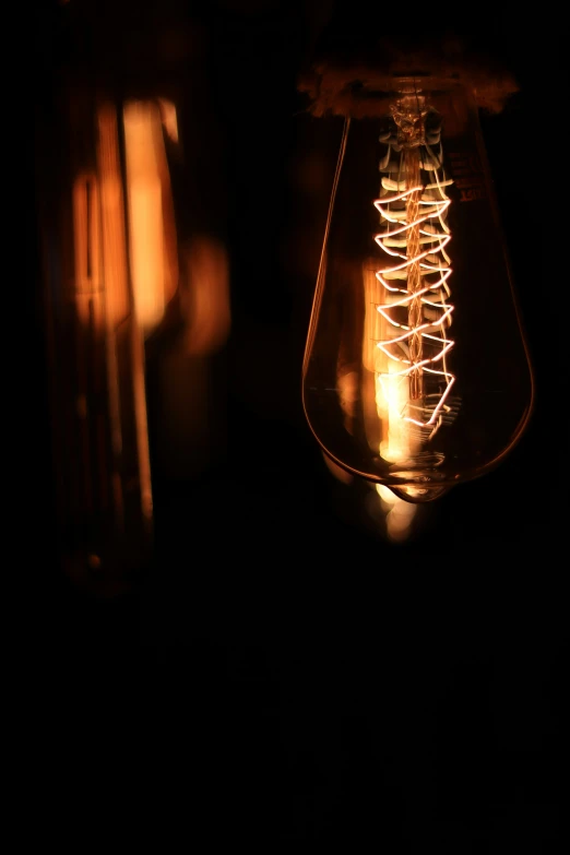 a glowing light bulb is being lit by someone