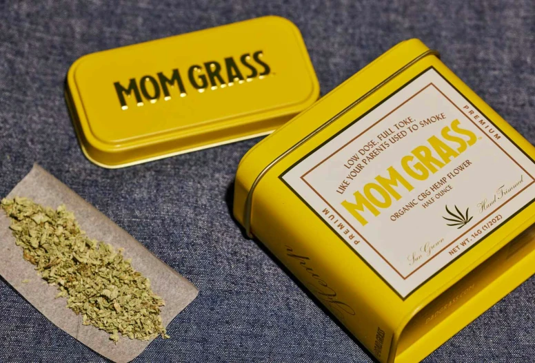 an orange tin of mom grass with a green and white box next to it