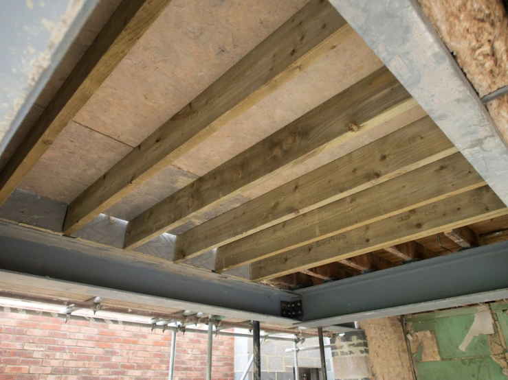 a brick building with a wooden roof and metal beam