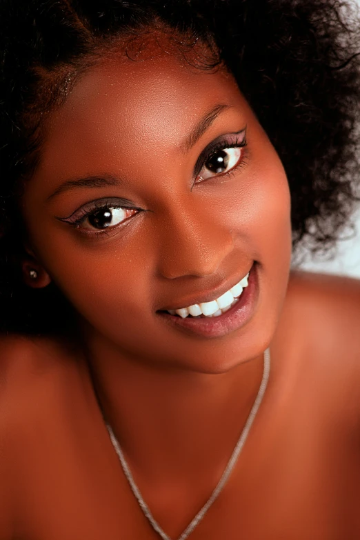 a woman with an unusual necklace smiles