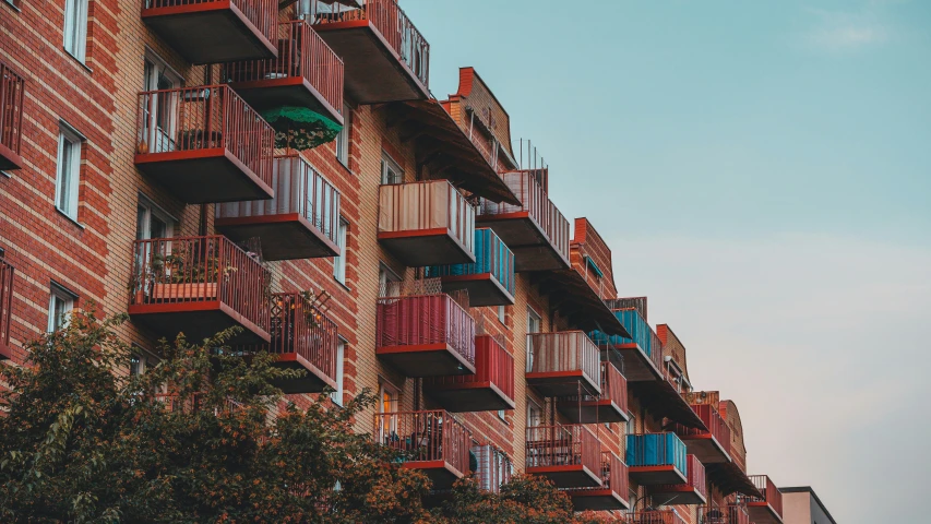 an apartment building that has colorful balconies on top