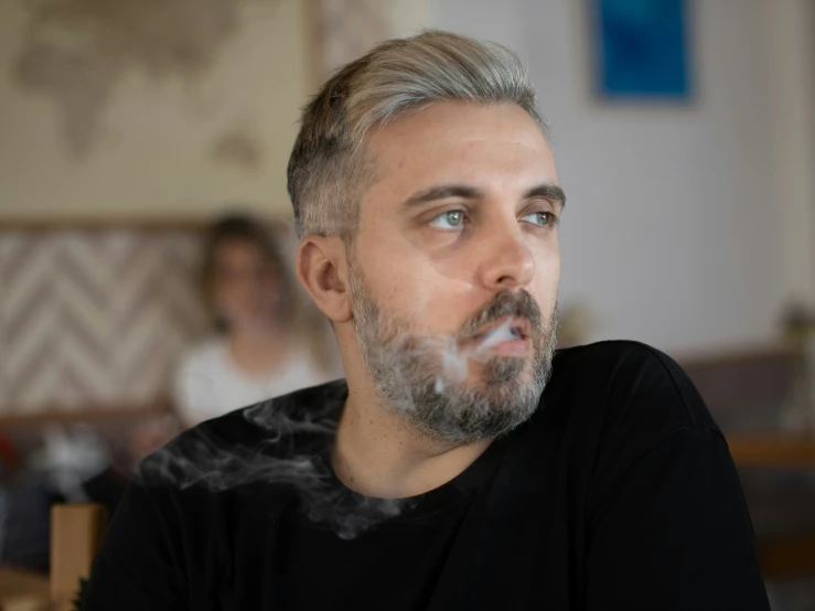 a man with grey hair smoking on the cigarette