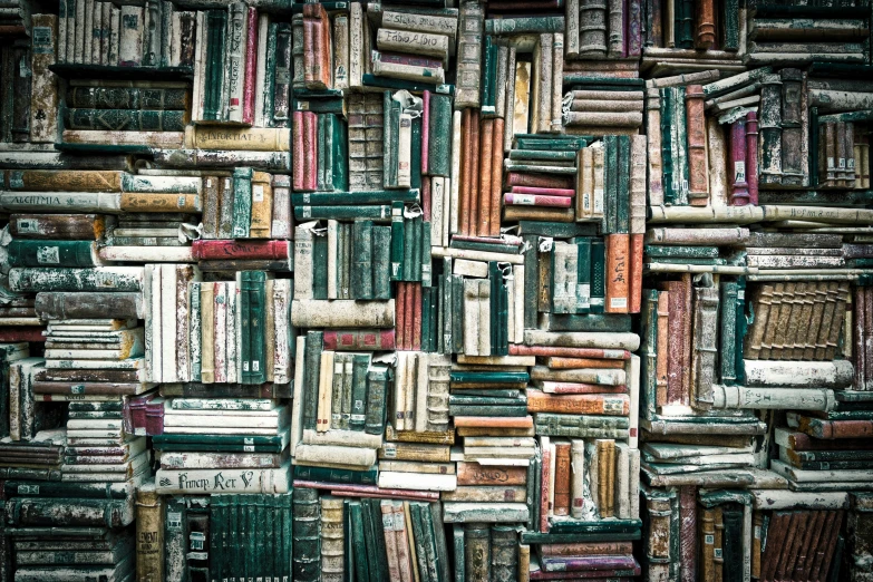 a pile of books are stacked in a wall