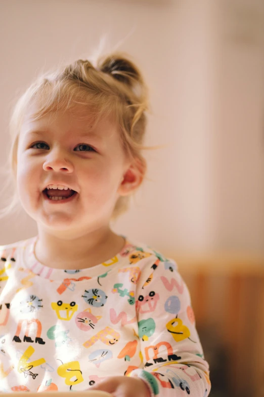 a smiling toddler holding a box with food in her hands