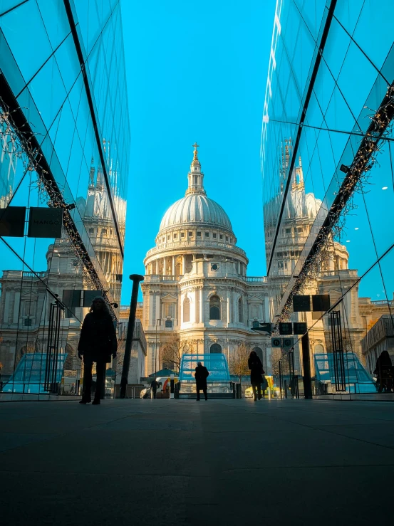 the people stand outside by the building with the domed dome in the center