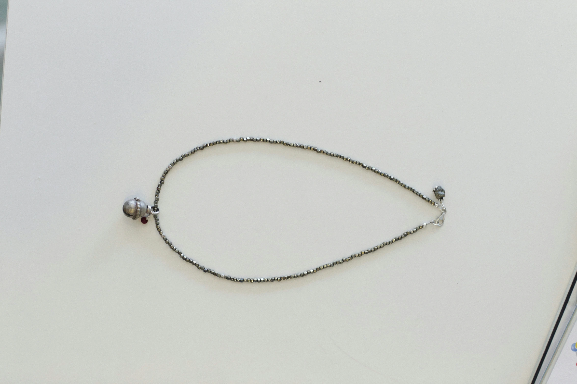a silver necklace with beads on the bottom