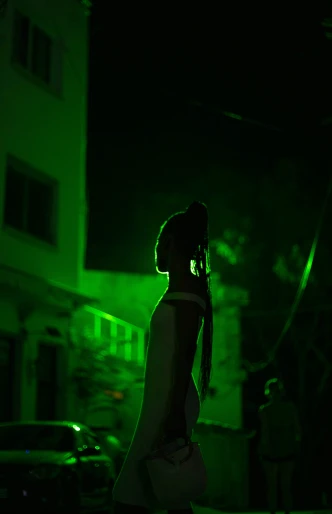a woman standing in front of a green light