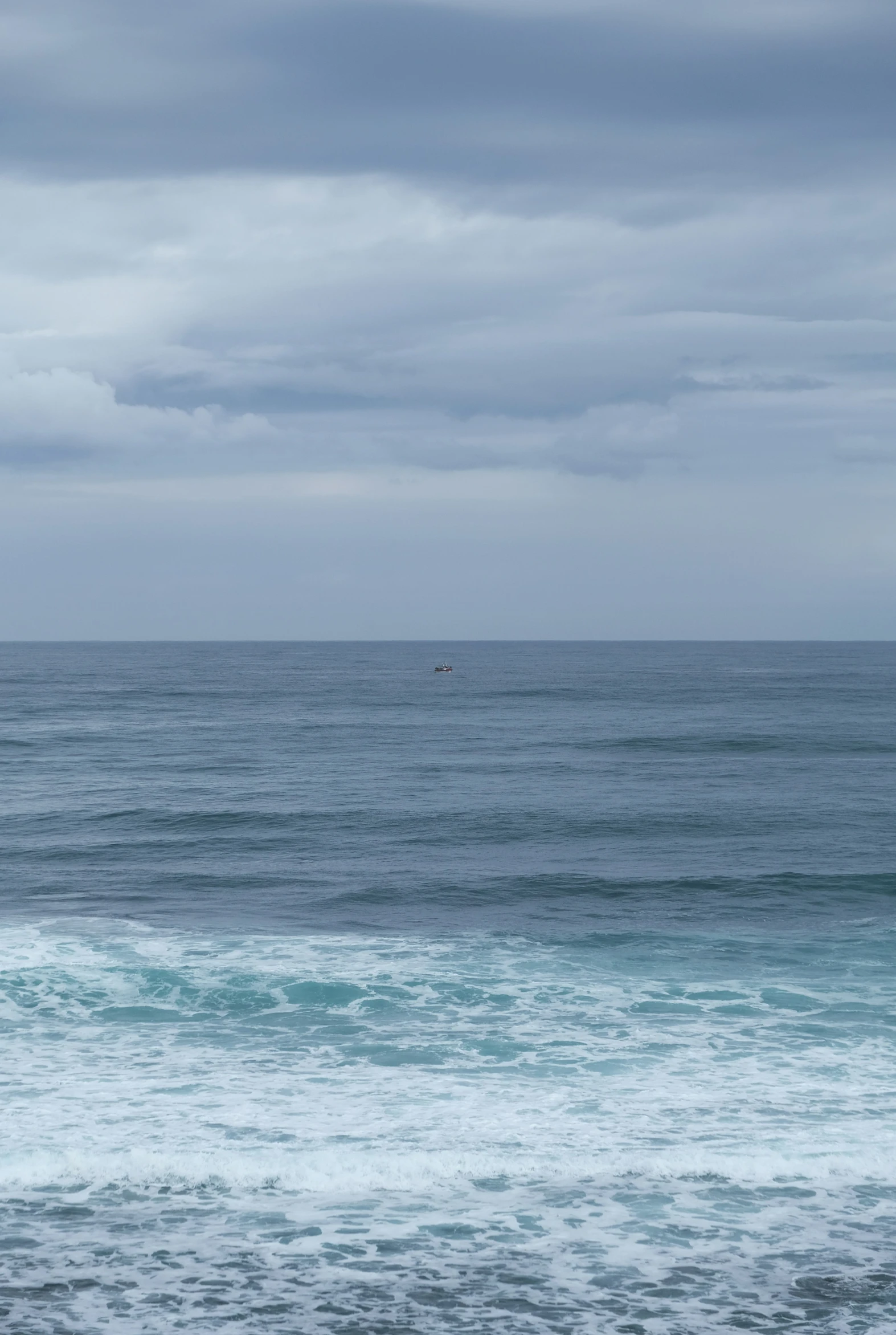 the sail boat is riding across the horizon