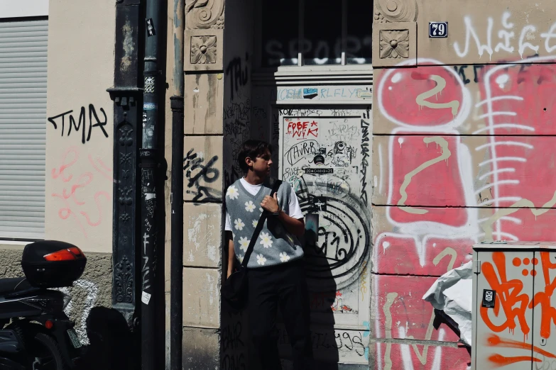 a man standing in front of a building near a motorcycle