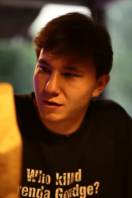 a young man holding a yellow cell phone