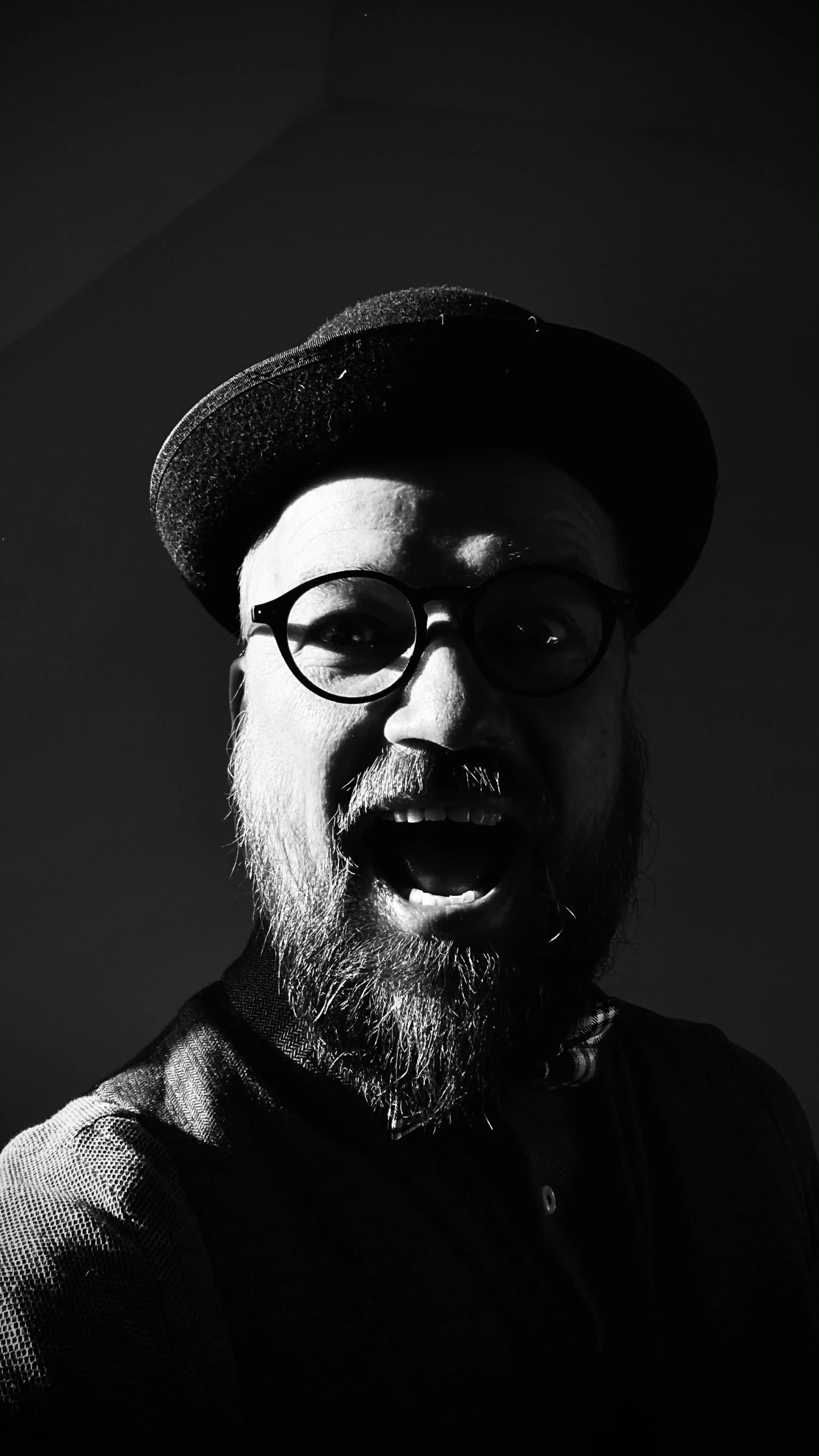 black and white pograph of a man with glasses and hat