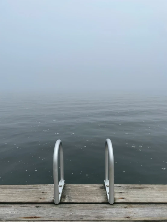 an empty wooden deck with stairs in the water