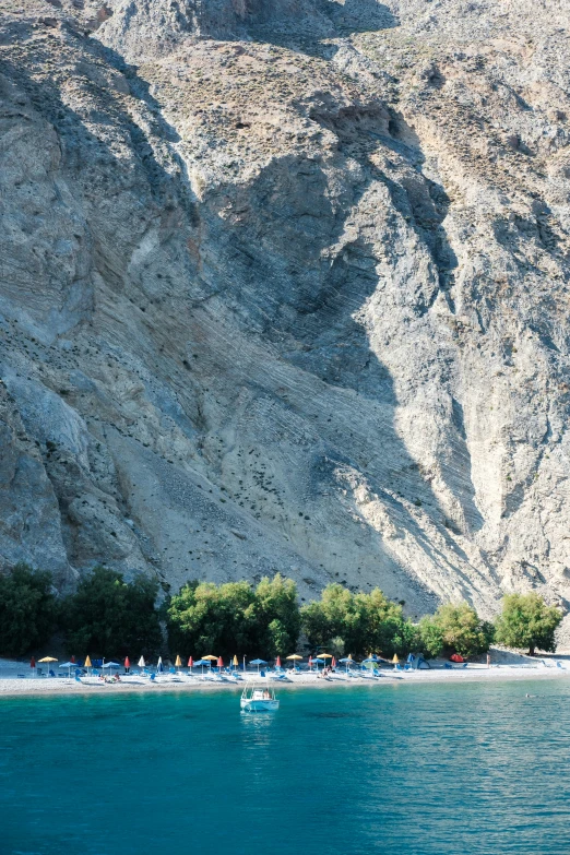 boats are floating on the blue ocean next to some mountains