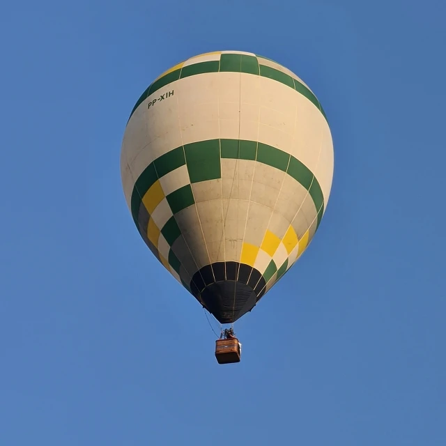 the large balloon is flying in the blue sky
