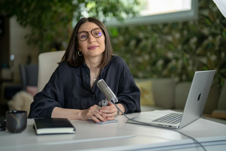 a woman sitting at a desk using a cell phone