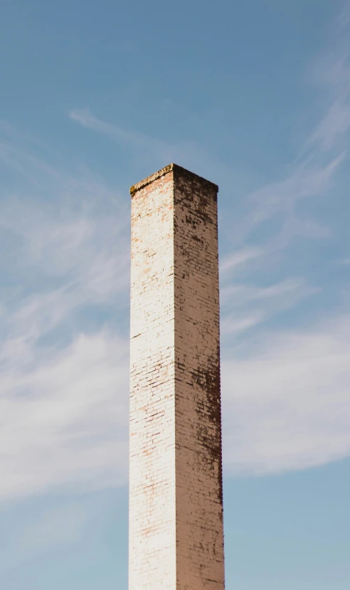 a tall brick monument against a blue sky