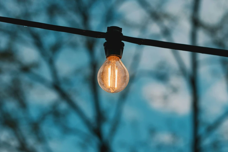 an open light bulb hangs from an electrical wire