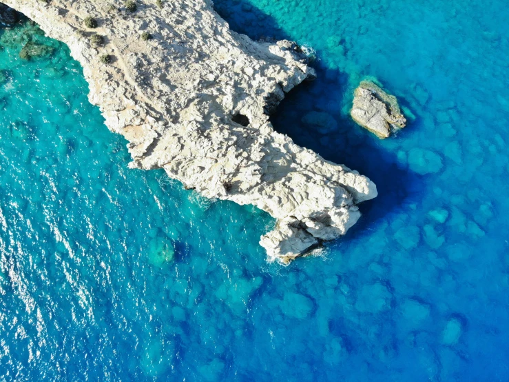 an aerial view of some blue water and rock formations