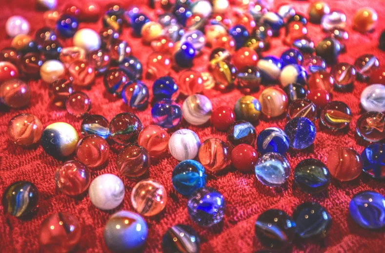 glass marbles laying on a red cloth