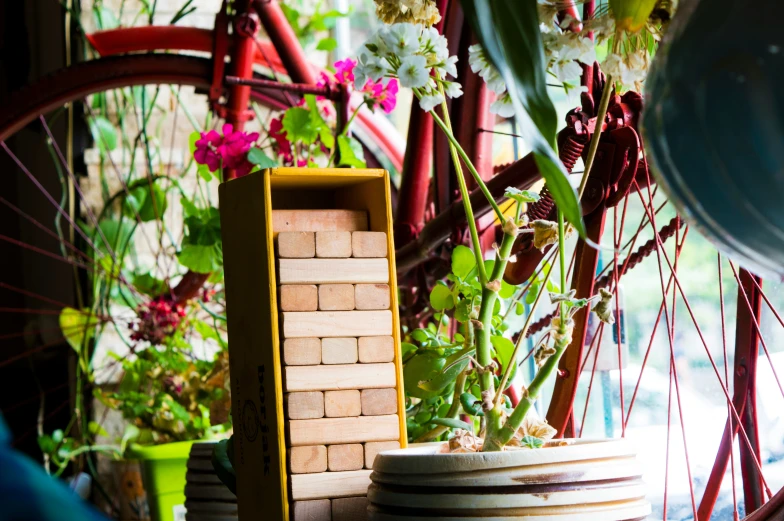 a wheel sits near a small house made of blocks