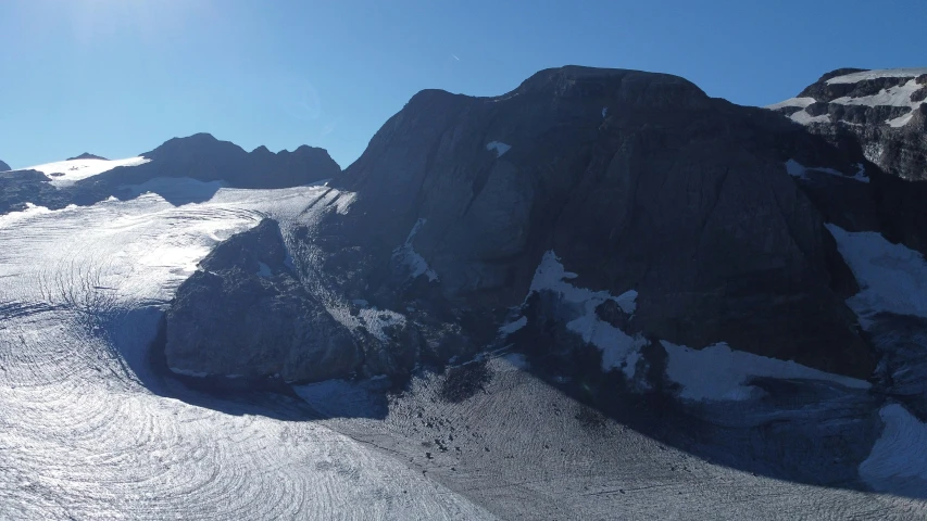 a very large rocky mountain with a huge amount of snow on it