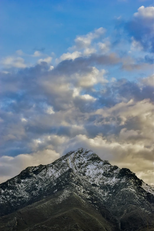 the snow is on the mountains under the clouds