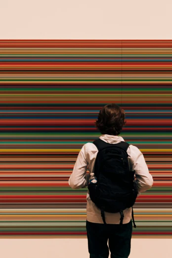 a person with a back pack looking at a colorful painting