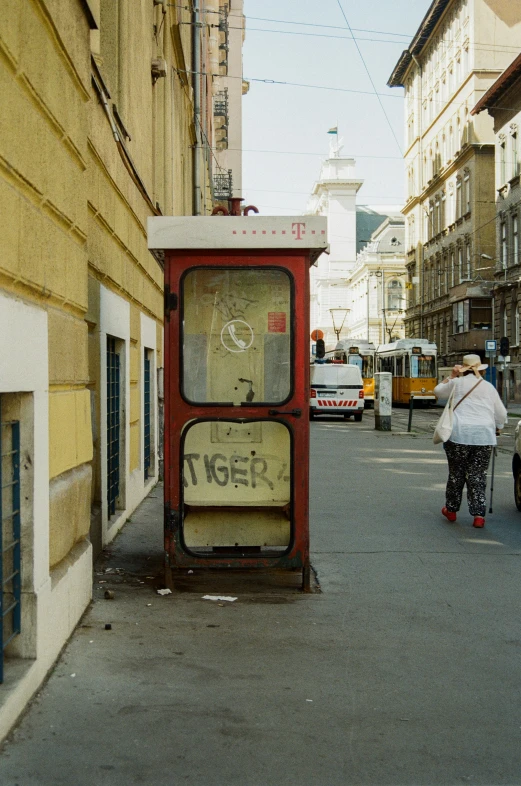 a tall red box sitting on the side of a street