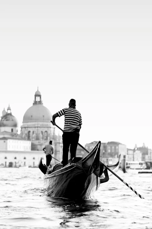 a man standing on top of a boat holding a paddle