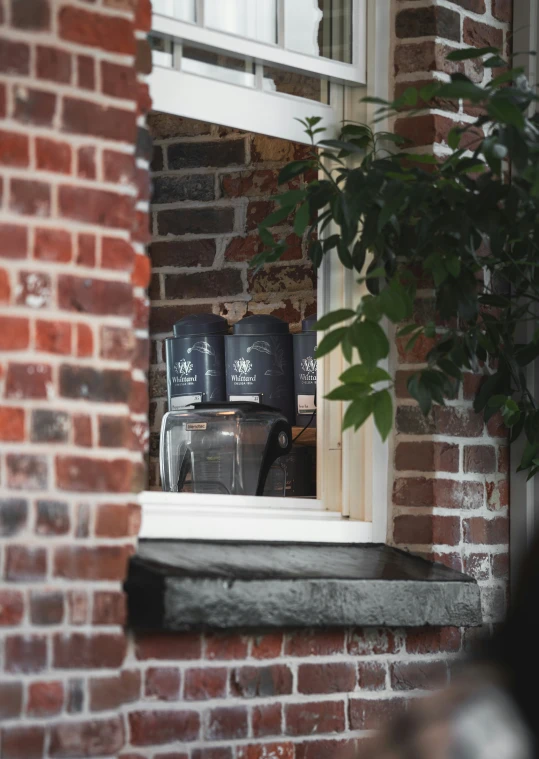 four plastic cans sitting on top of a window sill