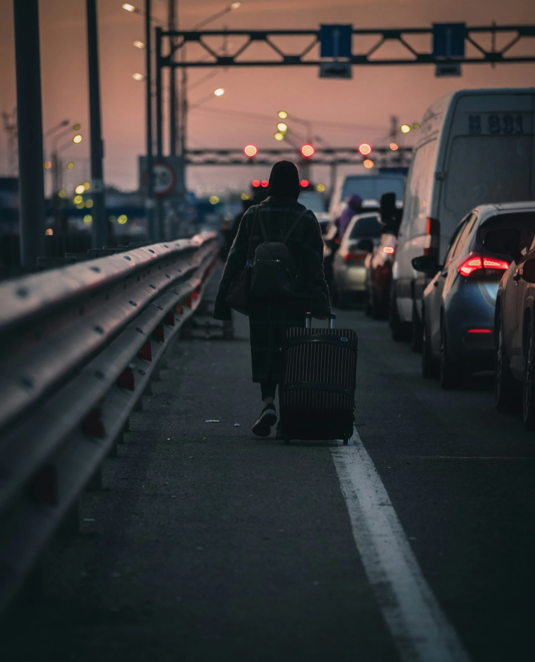 a man pulling a suitcase behind him and other cars next to the street