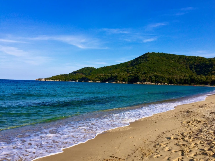 the shore is littered with sand and blue waters