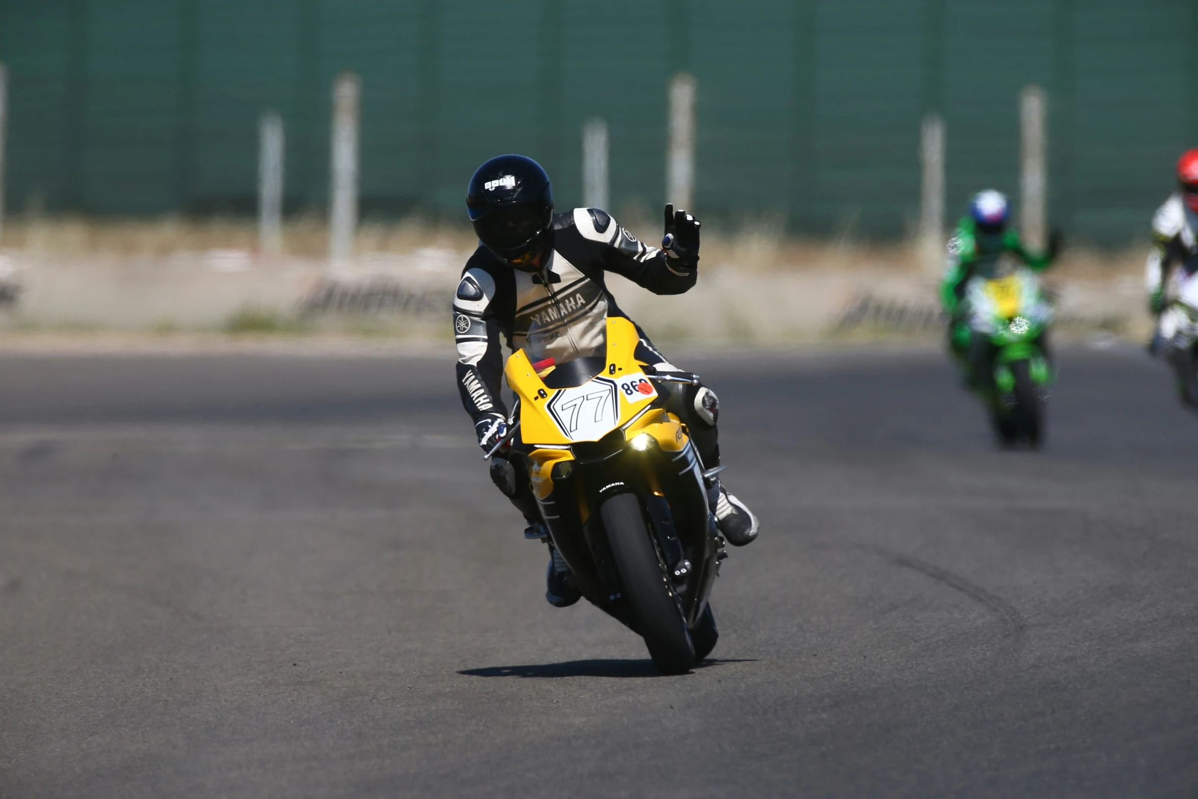 people riding motorcycles on a track with one of them behind the other