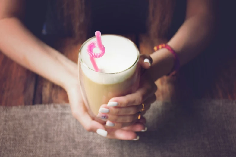 a woman holding a drink in her hands