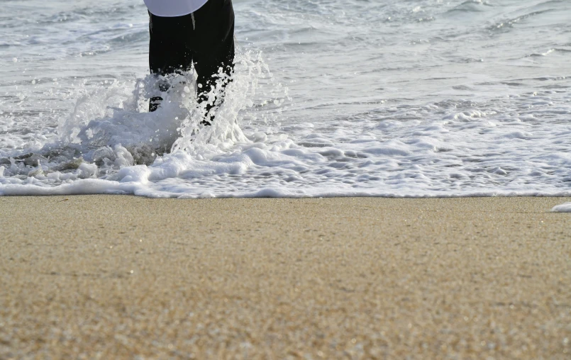 the person is wading in the water at the beach