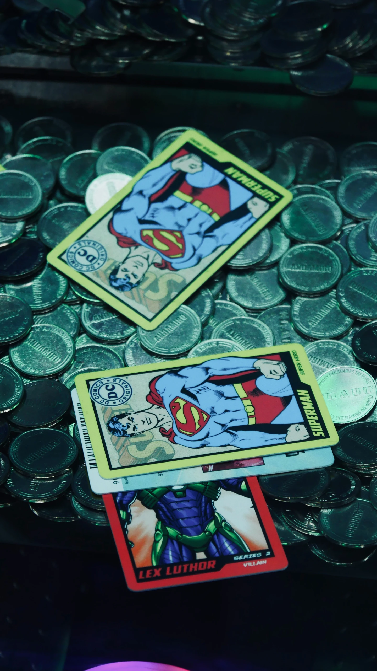 superman playing cards on top of some plastic coins