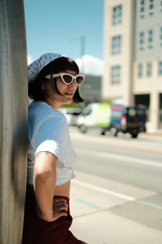 a person wearing sunglasses is sitting on a pole