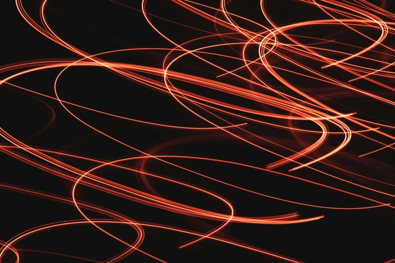 an abstract red image of light streaks against black background