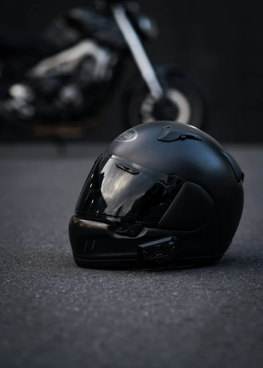 a black helmet laying on the ground next to a motorcycle
