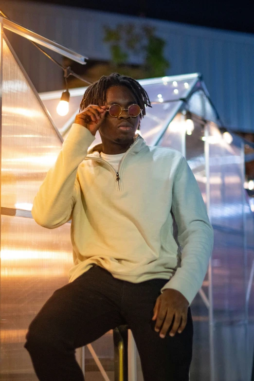 a man with glasses sitting on top of a chair