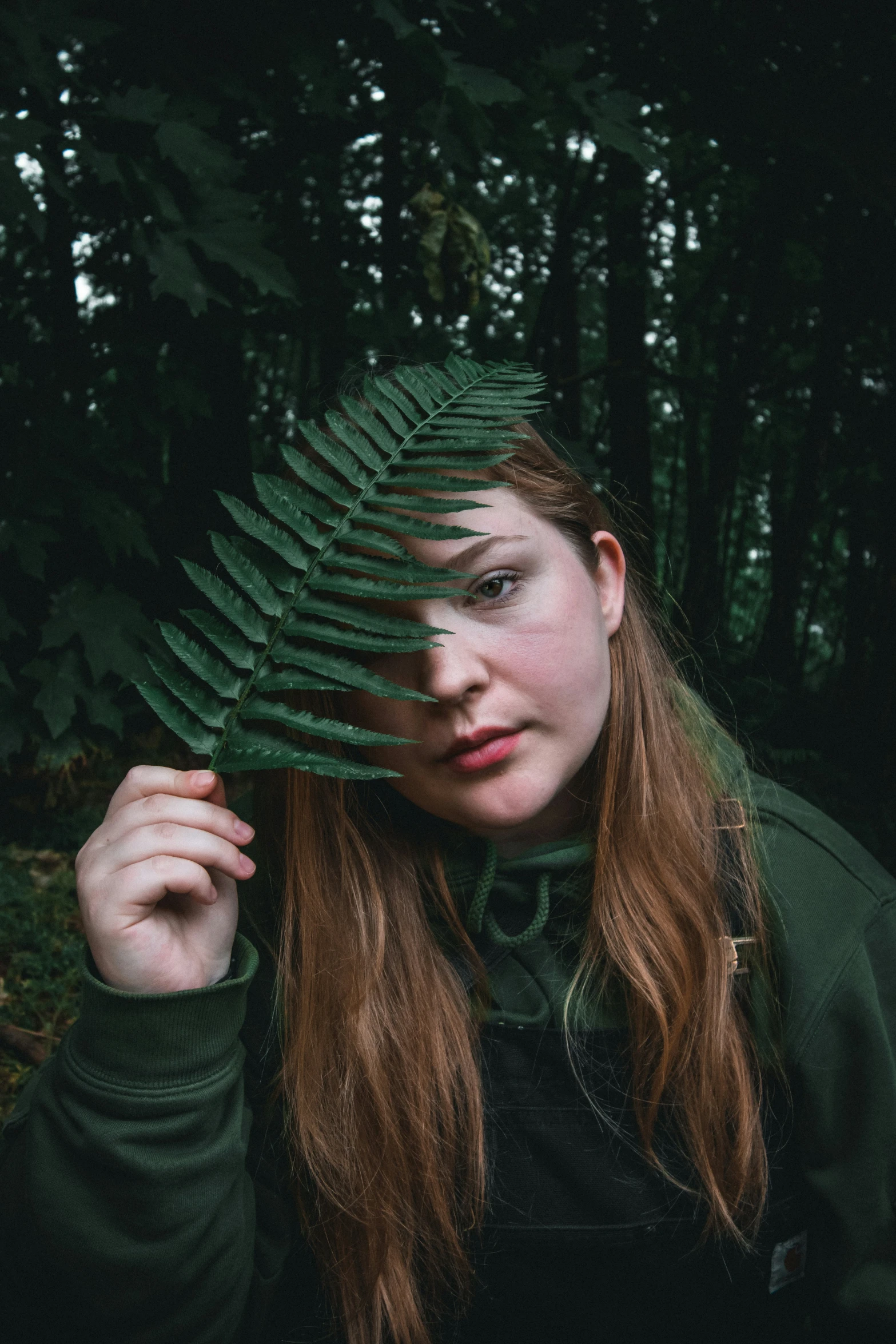 woman holding a leaf on the side of her face