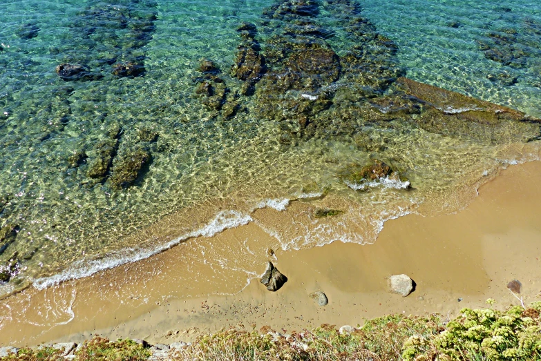 water waves on beach and rocks covered sand