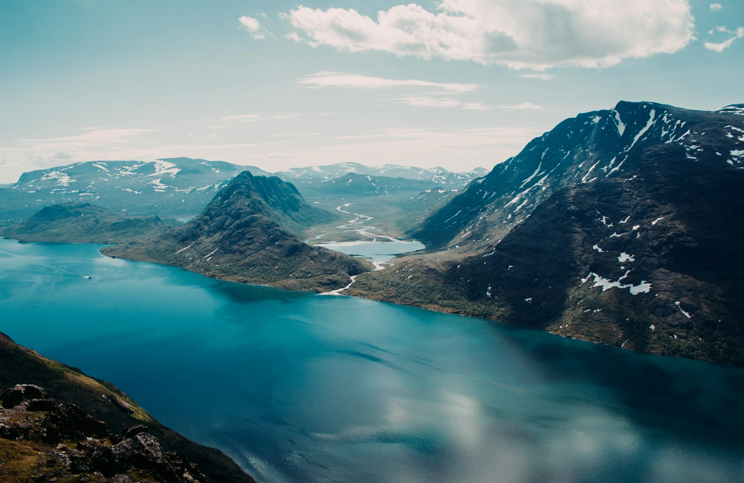 a lake sits in the middle of a mountain range