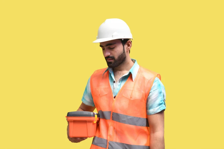 a construction worker in orange vest checking his electronic device