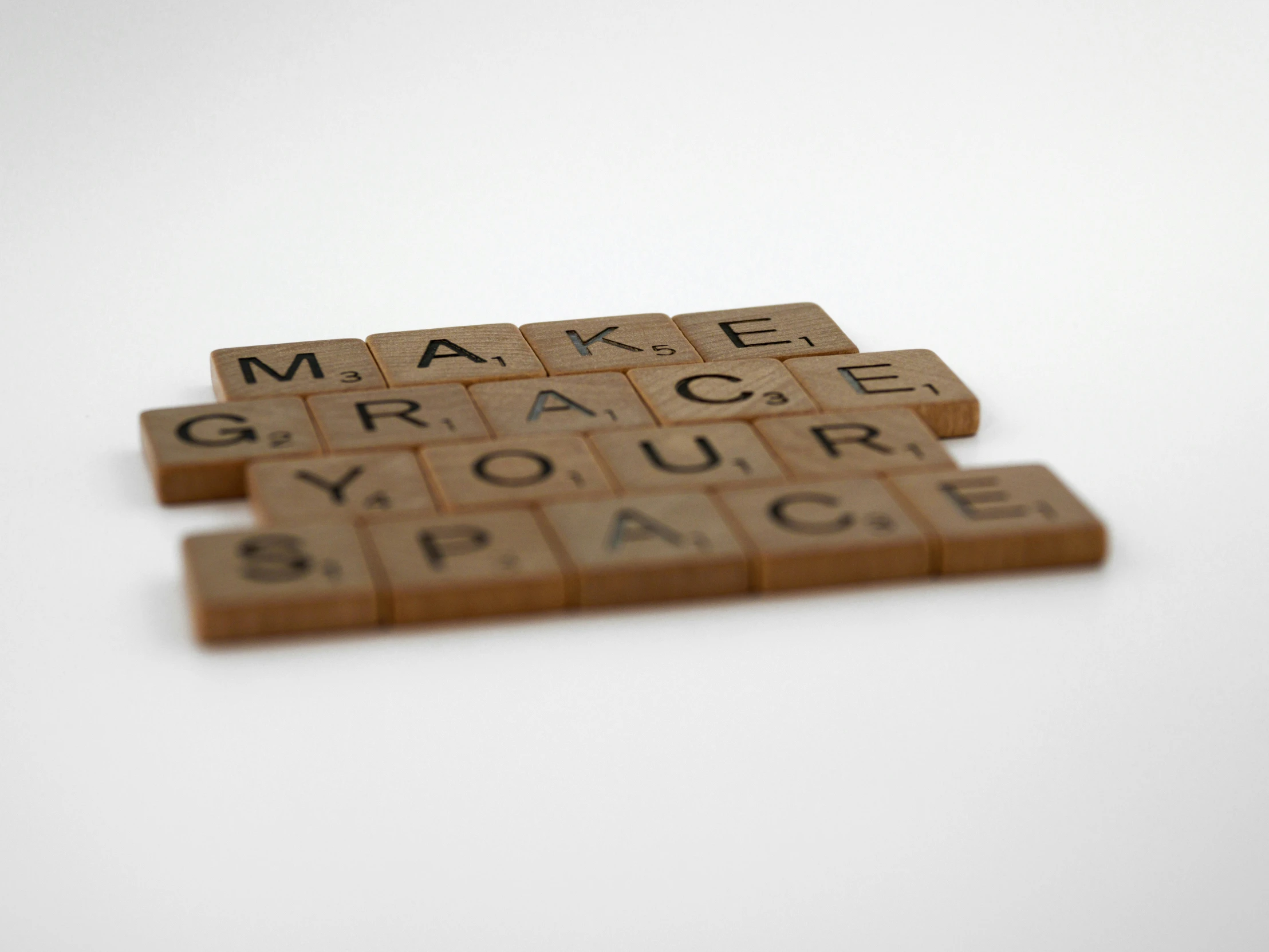 a close up of scrabble letters spelling make grace