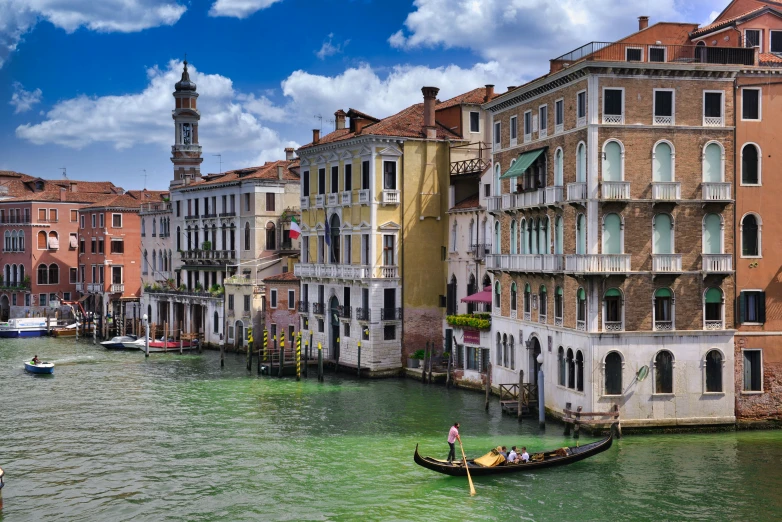 two gondola boats passing by a row of colorful buildings on the water