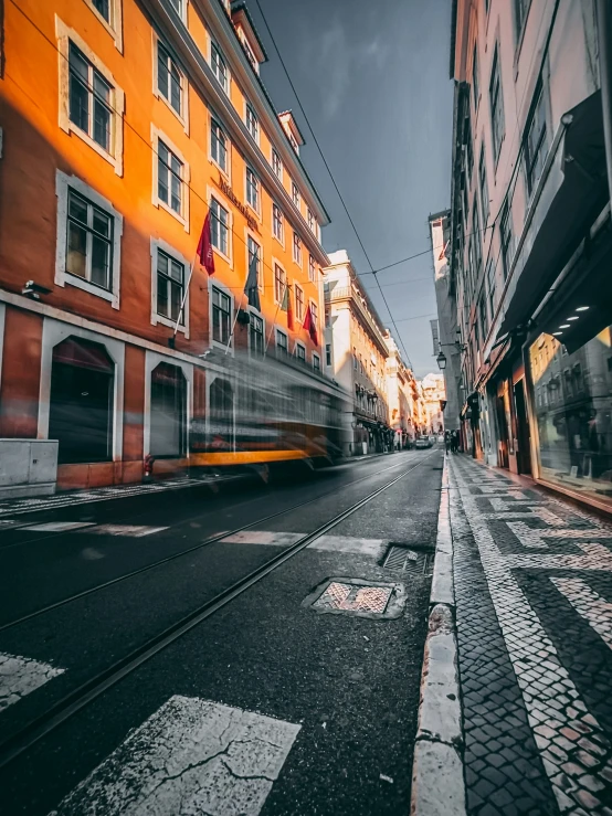 the bus is driving on the street between two buildings