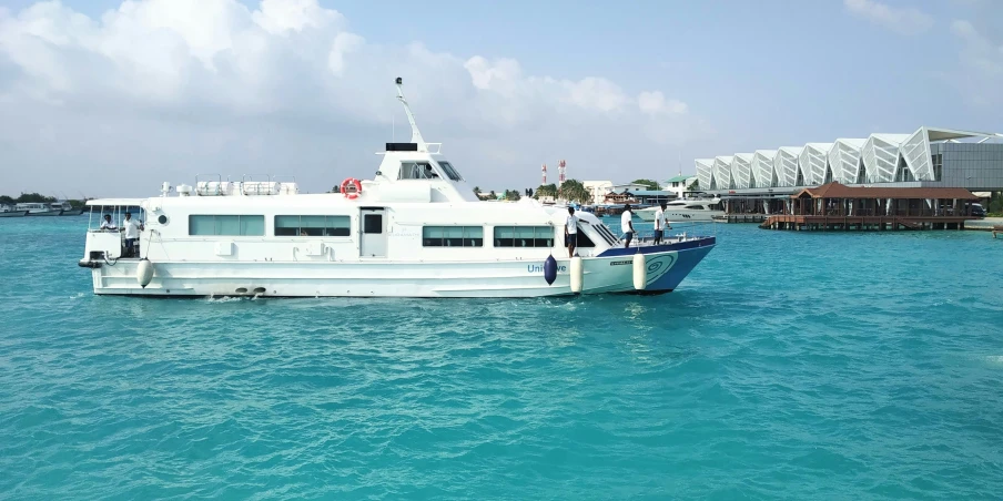 a blue and white boat traveling across a body of water